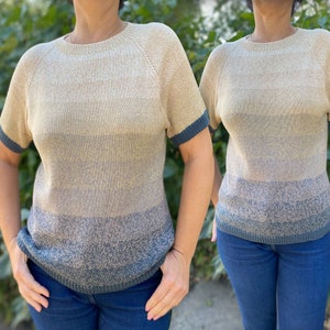 May include: A beige, grey, and blue striped knit shirt with short sleeves and a round neckline.