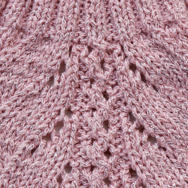 May include: Close-up of a pink knitted fabric with a sparkly silver thread woven throughout. The fabric has a delicate openwork pattern.