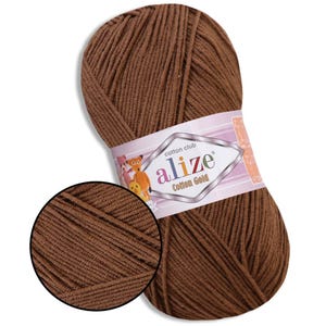 Puede incluir: Ovillo de hilo Alize Cotton Gold marr&oacute;n. El hilo est&aacute; bien enrollado y tiene un aspecto texturizado. La etiqueta presenta el nombre de la marca y personajes de dibujos animados. Ideal para proyectos de punto y ganchillo.