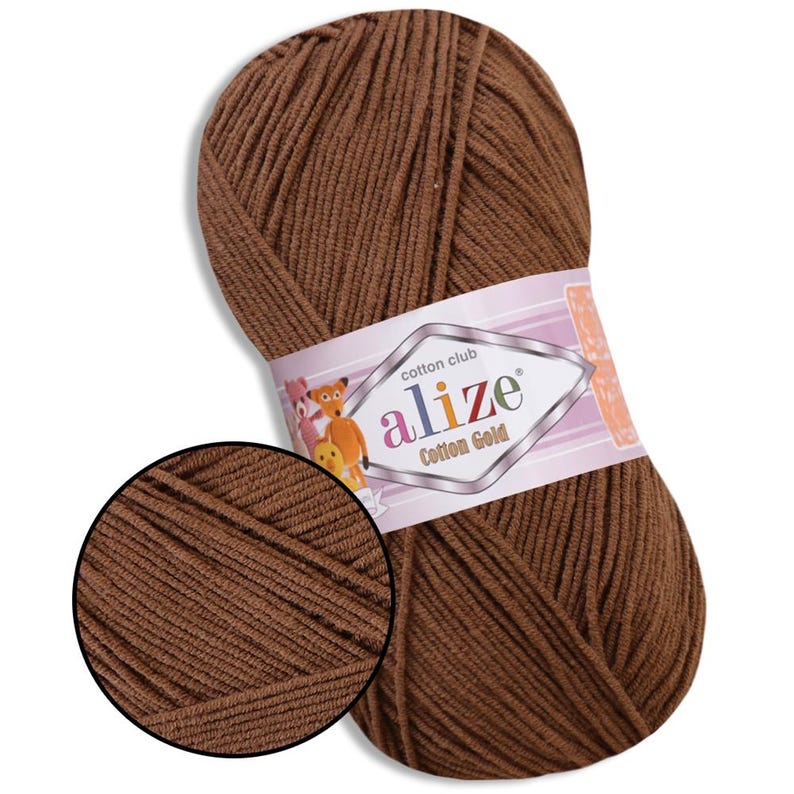 Puede incluir: Ovillo de hilo Alize Cotton Gold marr&oacute;n. El hilo est&aacute; bien enrollado y tiene un aspecto texturizado. La etiqueta presenta el nombre de la marca y personajes de dibujos animados. Ideal para proyectos de punto y ganchillo.