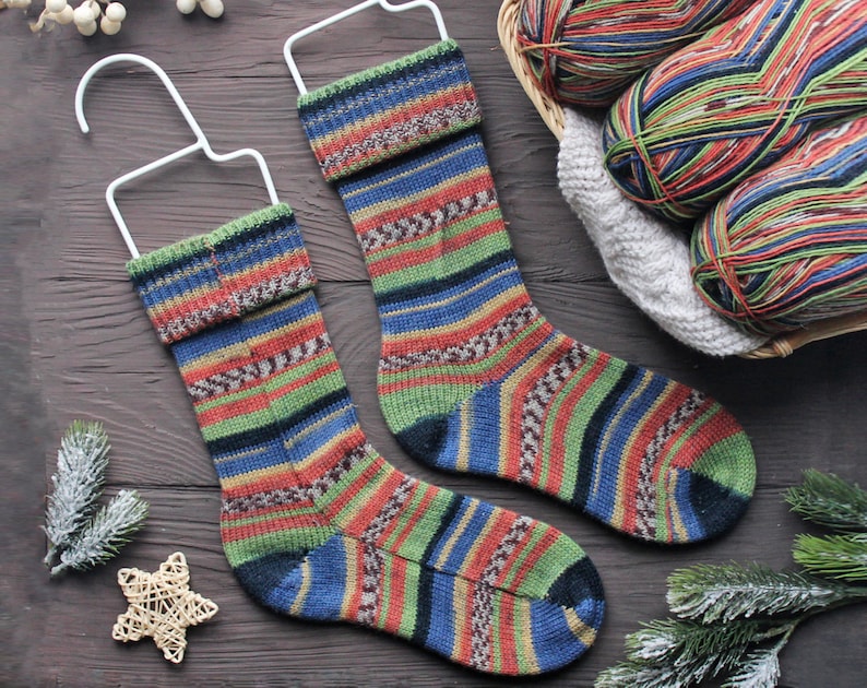 Two matching knitted socks with a colorful stripe and Fair Isle pattern.