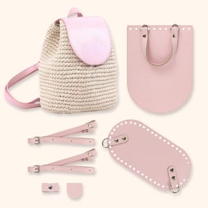 May include: A light pink and cream-colored backpack with matching straps and a flap. The backpack is made of a woven material with a pink leather flap and straps. Additional pink leather components are also included.