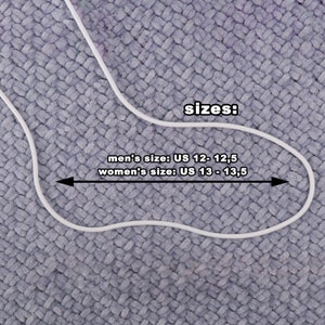 May include: A white outline of a foot with the text "sizes: men's size: US 12 - 12,5 women's size: US 13 - 13,5" on a gray textured background.