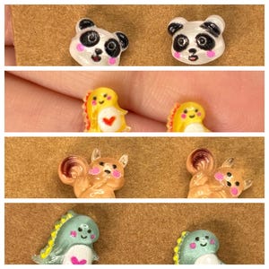 May include: A collection of colorful, miniature animal-themed charms. The charms include panda bears, dinosaurs, and squirrels. The panda bears are white with black markings and pink cheeks. The dinosaurs are yellow and green. The squirrels are brown.