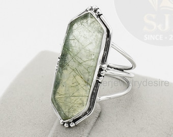 Könnte beinhalten: Ein silberner Ring mit einem großen, rechteckigen, grünen Edelstein. Der Edelstein hat ein einzigartiges, marmoriertes Muster. Der Ring hat ein schlichtes, elegantes Design.