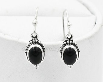 May include: A pair of silver earrings with black oval gemstones. The earrings have a delicate, ornate design.