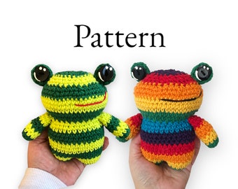 May include: Two crocheted frog plushies, one green and yellow striped and one rainbow striped. Both have black button eyes and a red stitched smile.