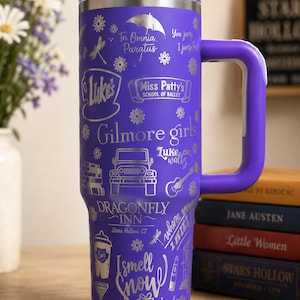 Pu&ograve; includere: Un bicchiere termico viola in acciaio inossidabile con manico, con disegni incisi in argento e testo relativo alla serie TV "Gilmore Girls". Il bicchiere include frasi come "Luke's", "Dragonfly Inn" e "I smell snow".