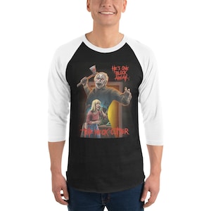 Pode incluir: Uma camiseta de beisebol preta e branca com um gráfico de um homem segurando um machado e uma mulher parecendo assustada. O texto na camiseta diz "He's one block away. The Neck Cutter."