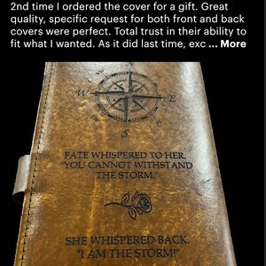 May include: A brown leather journal cover with a compass design, a rose, and the text "Fate whispered to her, "You cannot withstand the storm." She whispered back, "I am the storm!"