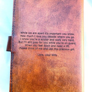 May include: A brown leather journal with a stitched border and a clasp closure. The journal has a heartfelt message engraved on the front, including the words "Love, your Wife."