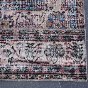 Puede incluir: Primer plano de una alfombra vintage con un patr&oacute;n floral en tonos rojos, azules y verdes. La alfombra tiene un borde con flecos y est&aacute; hecha de tejido tejido.