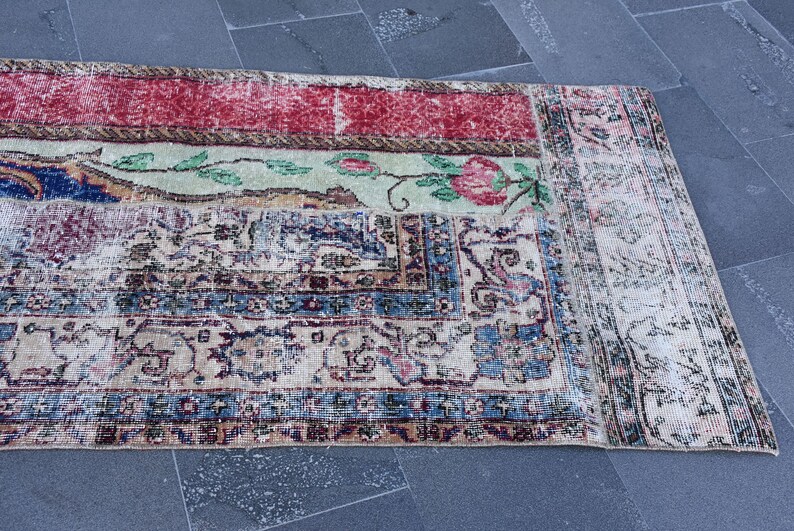 Puede incluir: Una alfombra vintage con un patr&oacute;n floral descolorido en tonos rojos, azules y verdes. La alfombra tiene un aspecto desgastado y est&aacute; hecha de un material suave y tejido.