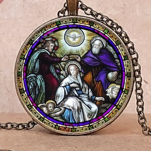 May include: Antique bronze bezel necklace with a stained-glass style religious scene. The pendant shows figures in robes, a dove, and a halo. The necklace has a chain and clasp. The image includes the text "Christian Pendants".