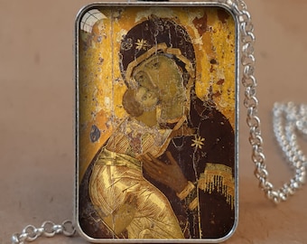 May include: Antique silver bezel necklace featuring a religious icon. The rectangular pendant displays a gold and brown image of a religious figure. The chain is silver and has a lobster clasp. Text on the image says "Antique Silver bezel + necklace" and "also available in Antique Bronze".