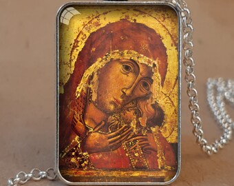 Puede incluir: Collar con colgante de bisel plateado antiguo con un icono religioso. El colgante rectangular muestra una imagen detallada de una madre y un niño en tonos dorados y rojos. La cadena es plateada y de diseño eslabonado. El texto "CHRISTIAN PENDANTS" es visible.