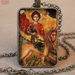 May include: Antique bronze bezel necklace featuring a religious icon. The rectangular pendant displays a figure in red and gold riding a lion. The chain and pendant frame have an antique finish. Text on the image reads "Christian Pendants".
