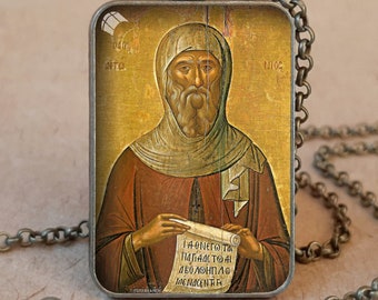 May include: Antique bronze pendant necklace featuring a rectangular pendant with an iconographic image of a religious figure. The pendant has a detailed image with text. The necklace is available in antique silver.