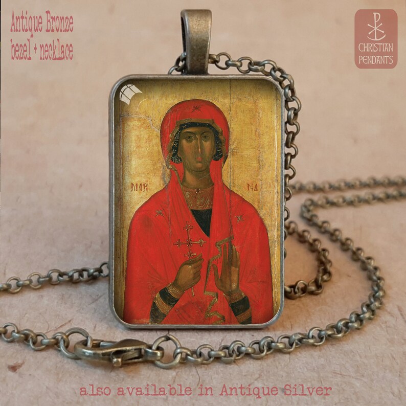 Puede incluir: Collar con colgante de bisel de bronce antiguo con un icono religioso. El colgante rectangular muestra una figura con t&uacute;nica roja sosteniendo una cruz. La cadena y el bisel tienen un acabado antiguo. El texto en la imagen dice "Antique Bronze bezel + necklace" y "also available in Antique Silver."