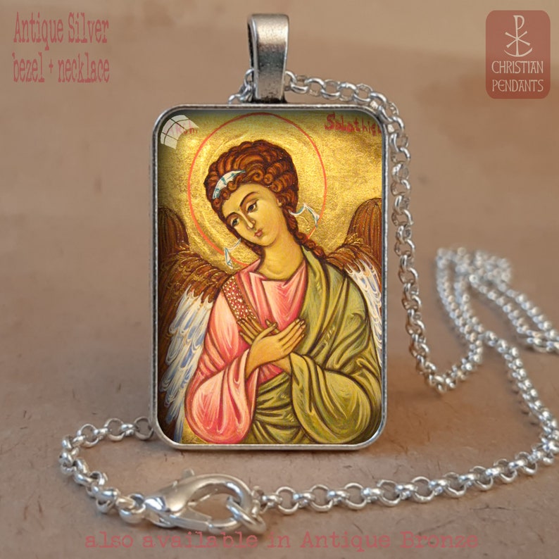 Puede incluir: Collar con colgante de bisel plateado antiguo con un icono religioso de un &aacute;ngel con halo dorado. El colgante rectangular muestra una pintura detallada en colores suaves, unido a una cadena plateada. El texto "Christian Pendants" es visible.