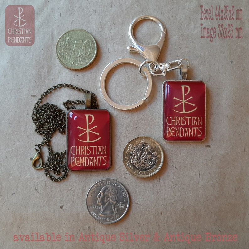May include: A collection of Christian pendants in antique bronze and silver. The pendants feature a red background with a gold Chi Rho symbol and the words "Christian Pendants." One pendant is on a chain, another on a keychain. A quarter, a pound coin, and a 50-cent coin are also shown.
