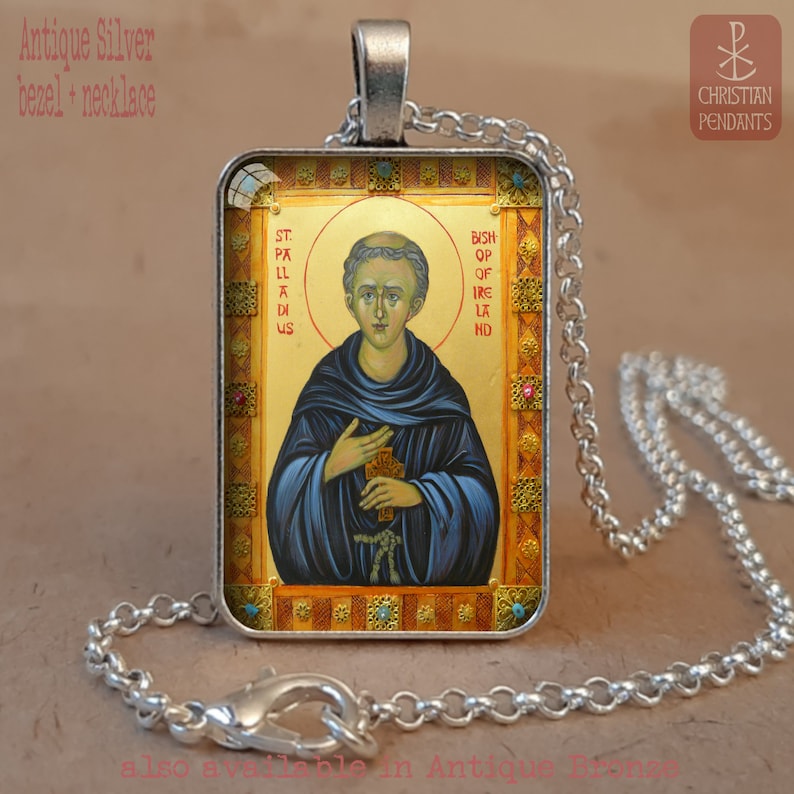 May include: Antique silver pendant necklace with a religious icon of a saint. The rectangular pendant has a detailed image with gold, blue, and red accents. The text "St. Palladius Bishop of Ireland" is visible. The necklace has a silver chain.