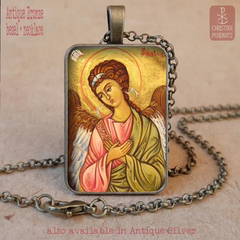 Puede incluir: Collar con colgante de bronce antiguo con un icono religioso de un &aacute;ngel y un halo dorado. El colgante rectangular presenta una imagen detallada del &aacute;ngel en tonos rosa, verde y marr&oacute;n. La cadena y el bisel del collar son de bronce antiguo.