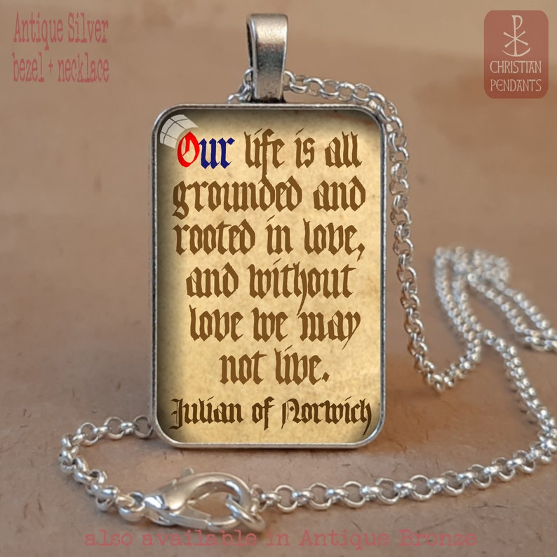 May include: Antique silver pendant necklace featuring a rectangular pendant with a quote from Julian of Norwich: "Our life is all grounded and rooted in love, and without love we may not live." The text is in a vintage style font.