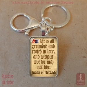 May include: A rectangular silver keychain with a quote from Julian of Norwich. The quote reads "Our life is all grounded and rooted in love, and without love we may not live." The keychain is also available in antique bronze.