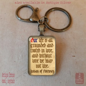 May include: Antique bronze keychain with a rectangular pendant. The pendant features a quote from Julian of Norwich: "Our life is all grounded and rooted in love, and without love we may not live."