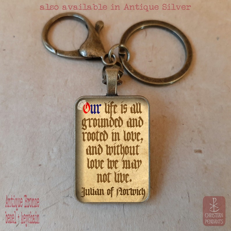 May include: Antique bronze keychain with a rectangular pendant. The pendant features a quote from Julian of Norwich: "Our life is all grounded and rooted in love, and without love we may not live."