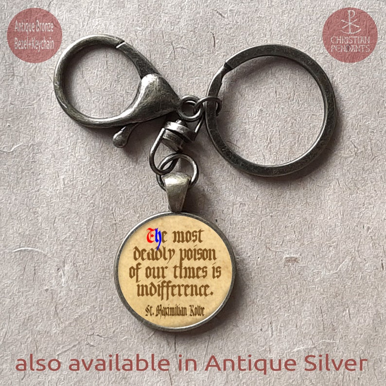 May include: Antique bronze bezel keychain with a round pendant. The pendant features the quote "The most deadly poison of our times is indifference" by St. Maximilian Kolbe. The text is in a gothic font. Also available in antique silver.