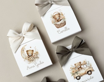 May include: Three white gift boxes with brown ribbon bows and teddy bear illustrations. The boxes are labelled "Camilla", "Anna Giulia", and "Leonardo".