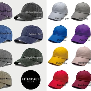May include: A collection of baseball caps in various colors, including burgundy, purple, and gray, with "Vintage" text. Other caps are in plain colors like light gray, black, and white. The caps are arranged in rows and columns.
