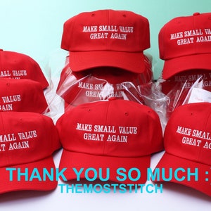 May include: Red baseball caps with white embroidered text that reads "MAKE SMALL VALUE GREAT AGAIN." The caps are arranged in a group, with the text "THANK YOU SO MUCH :)" and "THEMOSTSTITCH" at the bottom.