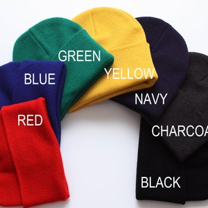 May include: A set of ten beanies in various colors, including red, blue, green, yellow, navy, charcoal, and black. The beanies are arranged in a circle on a white background.