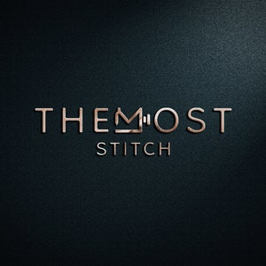 Op de afbeelding: Een logo voor een bedrijf genaamd "The Most Stitch" met een gestileerd kroonpictogram in het midden van het woord "Most".