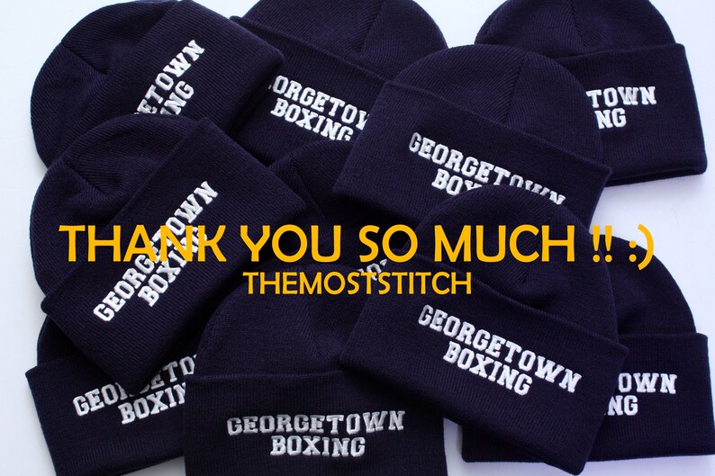 May include: A pile of navy blue knit beanies with white embroidered text that reads "Georgetown Boxing" and "Town NG". The text "Thank You So Much!! :) TheMostStitch" is visible in the image.