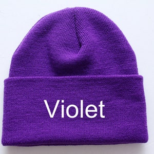 May include: A purple knitted beanie with the word "Violet" embroidered on the front.