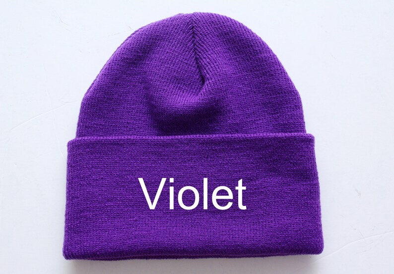 May include: A purple knitted beanie with the word "Violet" embroidered on the front.