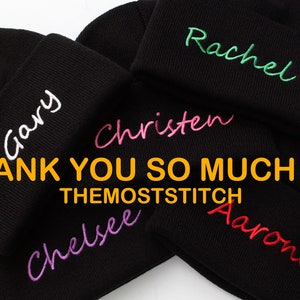 May include: Five black knit beanies with different names embroidered on them in various colors. The names are Gary, Rachel, Christen, Chelsea, and Aarone. The text "THANK YOU SO MUCH!!! :) THEMOSTSTITCH" is printed below the beanies.