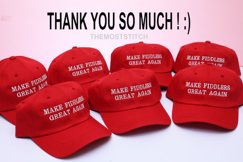 May include: Red baseball caps with the text "MAKE FIDDLERS GREAT AGAIN" in white. The caps are arranged in a group, with the text "THANK YOU SO MUCH ! :)" at the top. The shop name "THEMOSTSTITCH" is also visible.