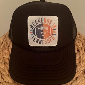 May include: Black trucker hat with a white patch featuring a football and the text "Weekends in Tennessee".