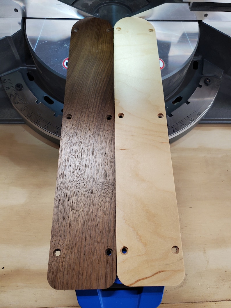 Puede incluir: Dos tablas de madera, una te&ntilde;ida de marr&oacute;n oscuro y la otra de madera natural, con varios agujeros perforados. Las tablas se colocan una al lado de la otra sobre una superficie azul.