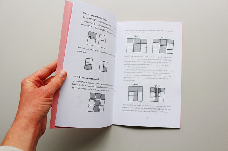 May include: A book with instructions on how to make a quilt block. The book has a pink cover and is open to a page with diagrams showing how to sew the pieces together. The text on the page reads "How to make a Quarter Square" and "How to sew a letter block".
