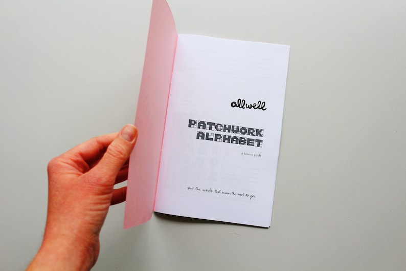 May include: A pink and white booklet with the title "Patchwork Alphabet" and the text "allwell" in a handwritten font. The text "a home-made guide" is also included. The booklet is open to reveal a page with the text "your five words that mean the most to you".