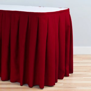 May include: A deep red table skirt with pleats, adding a touch of elegance to any event.