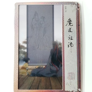 May include: A rectangular card featuring an anime-style illustration. The artwork depicts figures in traditional attire, with a central image of two figures and a kneeling child. The card has decorative borders and Japanese text.