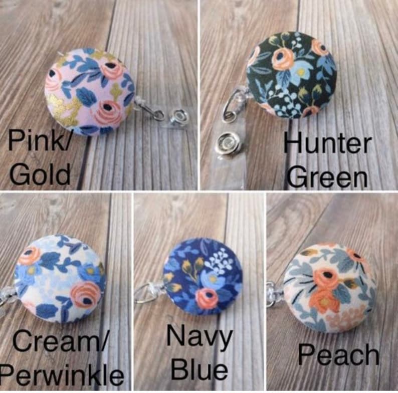 May include: Five different fabric covered buttons with floral patterns attached to retractable badge holders. The buttons are in the colors pink, hunter green, cream, navy blue, and peach.
