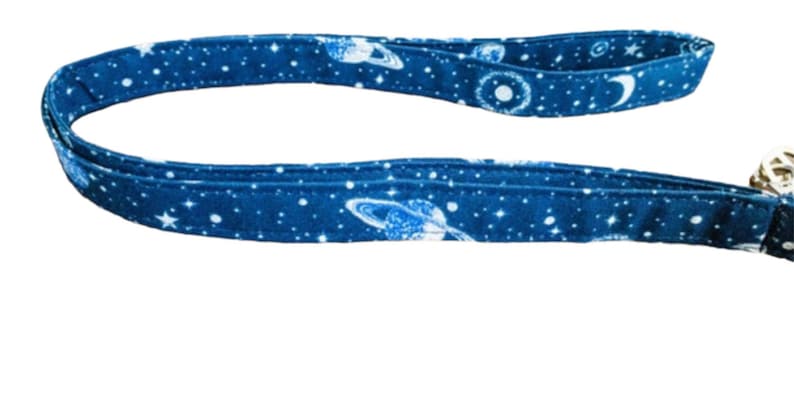 May include: A blue fabric leash with a white galaxy print featuring stars, planets, and moons.